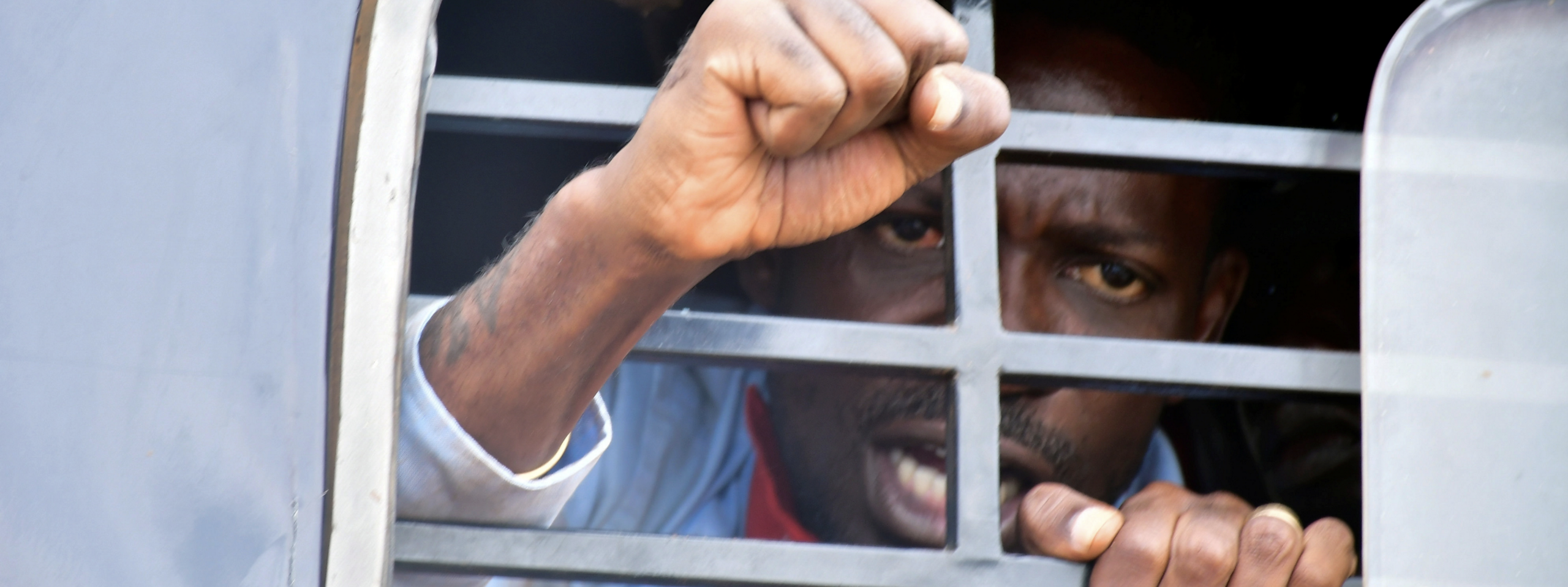 BANNER: Ugandan presidential candidate Robert Kyagulanyi, also known as Bobi Wine, reacts from inside a police van, in Luuka district, Uganda, November 18, 2020. (Source: REUTERS/Abubaker Lubowa)