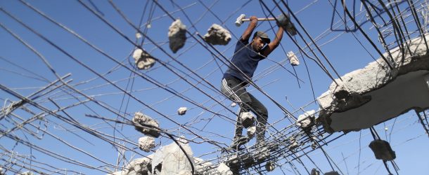 A Palestinian stands on a house that was destroyed in an Israeli air strike during the fighting between Israel and Hamas in May 2021, in the northern Gaza Strip on June 29, 2021. (Source: REUTERS/Mohammed Salem)