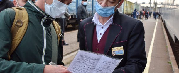 A passenger is seen showing his vaccination document to a train conductor in Ukraine, October 21, 2021. A vaccination certificate or a negative test is required for inter-city travel by train, bus or planes.