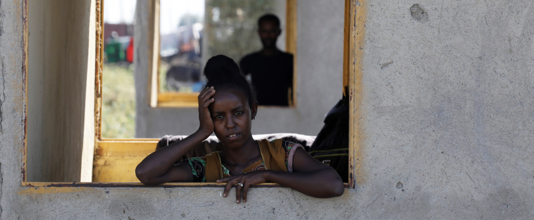 An Ethiopian woman stands at a window of a temporary shelter at the Village 8 refugee transit camp in Sudan, which houses refugees fleeing the fighting in Ethiopia’s Tigray region, December 2, 2020. 