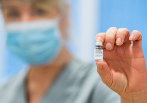 A nurse holds a vial of Pfizer-BioNTech Covid-19 vaccine doses in n Råå, Sweden on December 27, 2020.