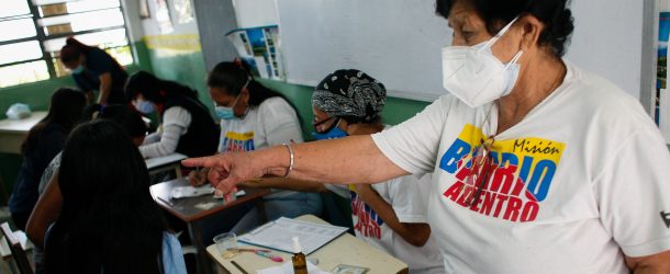 A health worker gestures during a day of immunization against Covid-19 with the compound manufactured in China Sinopharm aimed at high school students at a high school in the west of the city, in Caracas, Venezuela, October 29, 2021.