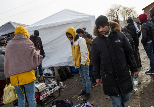People seen standing next to a generator while charging their phones at the Ukrainian-Polish border. Civilians fleeing the war in Ukraine for the safety of European border towns include citizens of African, Asian and Middle East countries.