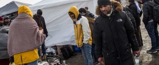 People seen standing next to a generator while charging their phones at the Ukrainian-Polish border. Civilians fleeing the war in Ukraine for the safety of European border towns include citizens of African, Asian and Middle East countries.