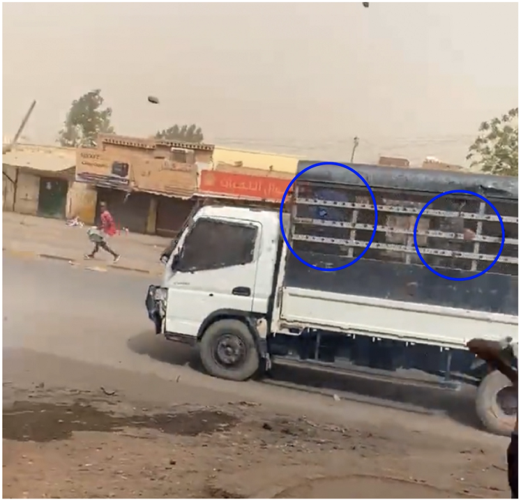 People wearing blue uniforms were recorded sitting in the back of an unmarked vehicle that drove towards Sudanese protesters at speed.