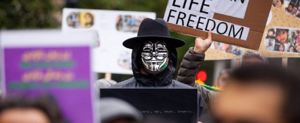 A person wearing Guy Fawkes mask, attends a solidarity protest for Mahsa Amini in Washington DC on October 1, 2022.