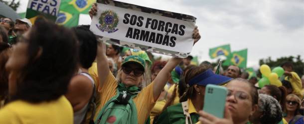 People gather during a protest held by supporters of Brazil’s President Jair Bolsonaro at the Army headquarters in Rio de Janeiro, Brazil, November 15, 2022. The sign reads: “SOS Army Forces.” (Source: REUTERS/Pilar Olivares)