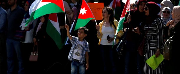 People hold Jordanian national flags as they take part in a protest during a teachers' strike in Amman, Jordan, October 3, 2019.