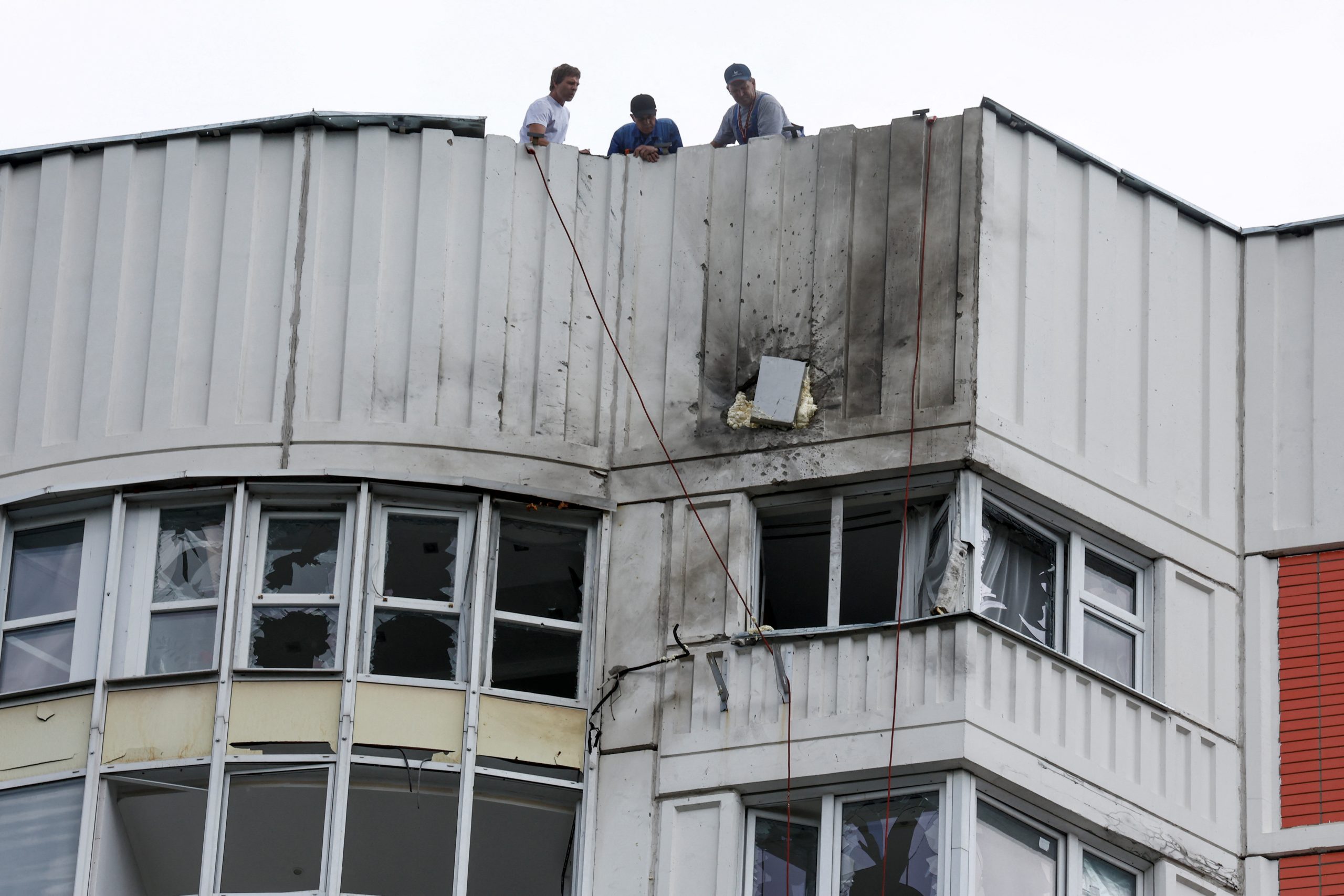Caption: Men are seen on the roof of a damaged apartment block following a reported drone attack in Moscow, May 30, 2023. (Source: Reuters/Maxim Shemetov)