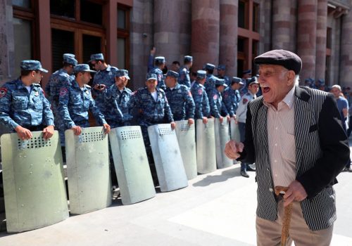 A protester reacts next to law enforcement officers during a gathering outside the government building following the launch of a military operation by Azerbaijani forces in the region of Nagorno-Karabakh, in Yerevan, Armenia, September 20, 2023. REUTERS/Irakli Gedenidze