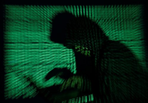 A hooded man holds a laptop computer as cyber code is projected on him in this illustration picture taken on May 13, 2017. Capitalizing on spying tools believed to have been developed by the U.S. National Security Agency, hackers staged a cyber assault with a self-spreading malware that has infected tens of thousands of computers in nearly 100 countries. REUTERS/Kacper Pempel/Illustration TPX IMAGES OF THE DAY