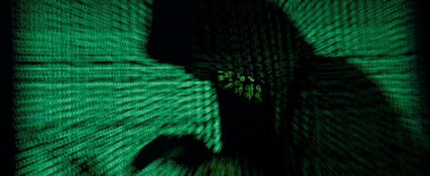 A hooded man holds a laptop computer as cyber code is projected on him in this illustration picture taken on May 13, 2017. Capitalizing on spying tools believed to have been developed by the U.S. National Security Agency, hackers staged a cyber assault with a self-spreading malware that has infected tens of thousands of computers in nearly 100 countries. REUTERS/Kacper Pempel/Illustration TPX IMAGES OF THE DAY