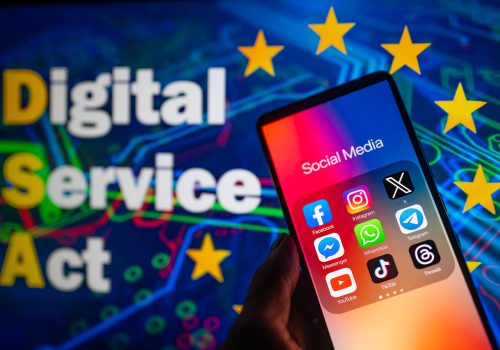 Social media icons logo displayed on a smartphone with European Commission Digital Service Act on screen seen in the background, in this photo illustration. On 19 October 2023, in Brussels, Belgium. Jonathan Raa / Nurphoto (Photo by Jonathan Raa/NurPhoto)