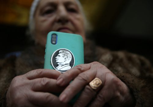 A woman holds a phone with a portrait of Soviet leader Josef Stalin on case, during an event marking the 70th anniversary of Stalin's death, in his hometown of Gori, Georgia March 5, 2023. (Source: REUTERS/Irakli Gedenidze)