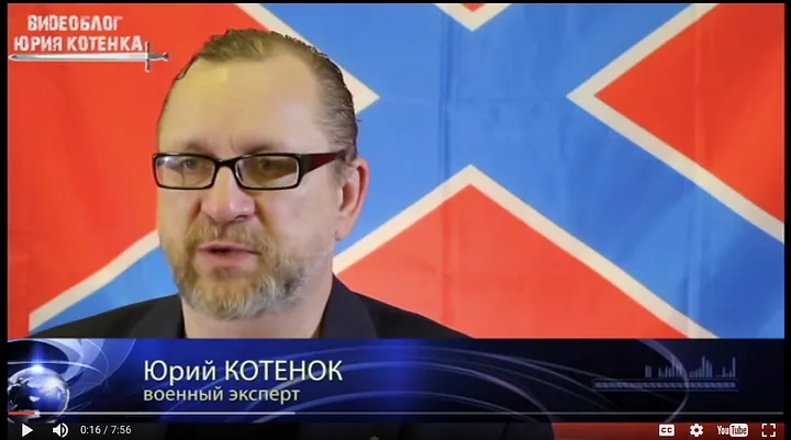 Screen shot of Kotenok, as a “military expert”, in front of a flag often used by separatists.