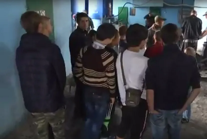 Schoolchildren taking a tour of the prison colony, with prisoners working in the background. Screen capture taken from LNR Vesti news broadcast from June 9, 2016 (source)