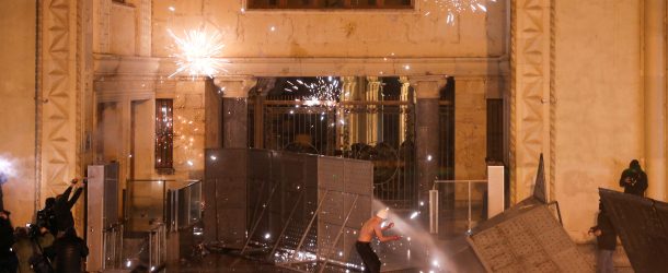 Fireworks explode outside the Georgian parliament building in Tbilisi as protesters attempt to break through barrier constructions during a rally against the bill known as the foreign agents law, March 8, 2023. (Source: Reuters/Irakli Gedenidze)