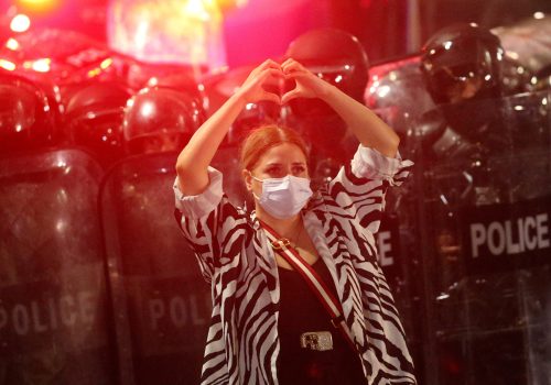 A demonstrator makes a heart-shaped gesture while standing in front of a police cordon during a rally to protest against the so-called foreign agents bill in Tbilisi, Georgia, May 1, 2024. (Source: REUTERS/Irakli Gedenidze/File Photo)