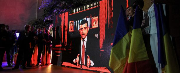 Supporters watch Leader of the radical right Alliance for the Union of Romanians (AUR) George Simion speak on a screen following the exit poll results during the Romanian presidential election, outside the Alliance for the Union of Romanians (AUR) headquarters in Bucharest, Romania